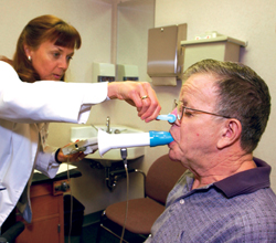 Man working with a respiratory therapist to check his breathing