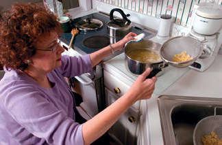 A woman in a wheelchair cooking pasta