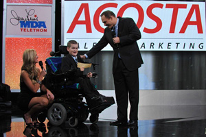 Executive Vice President of Retail Operations Brad Smith presents a check to Telethon co-hosts Nancy O'Dell and Luke Christie.