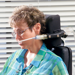 Woman using an assistive ventilation device attached to her power chair