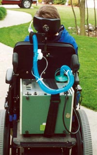 Mike N. in his power wheelchair with vent.