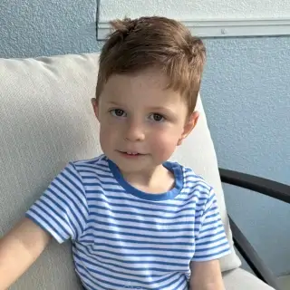 A picture of Will, sitting on a couch in a blue shirt.