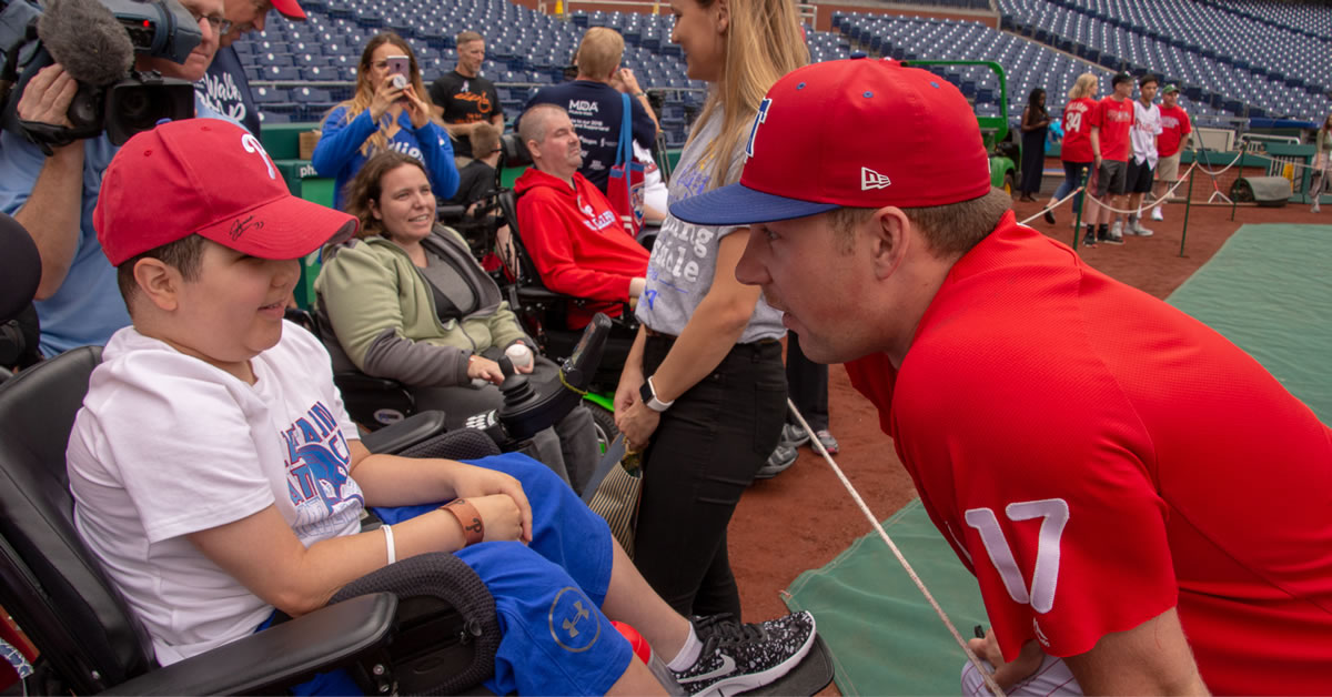 Image of Rhys Hoskins and a child in a baseball stadium.